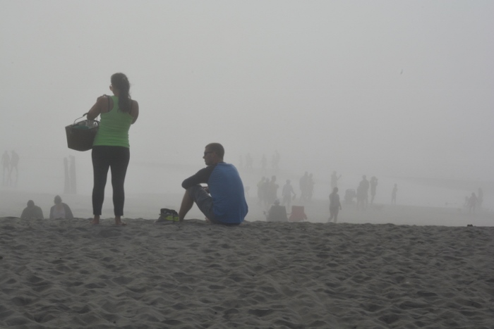 a couple in the foreground is more visible through the fog than those in the background